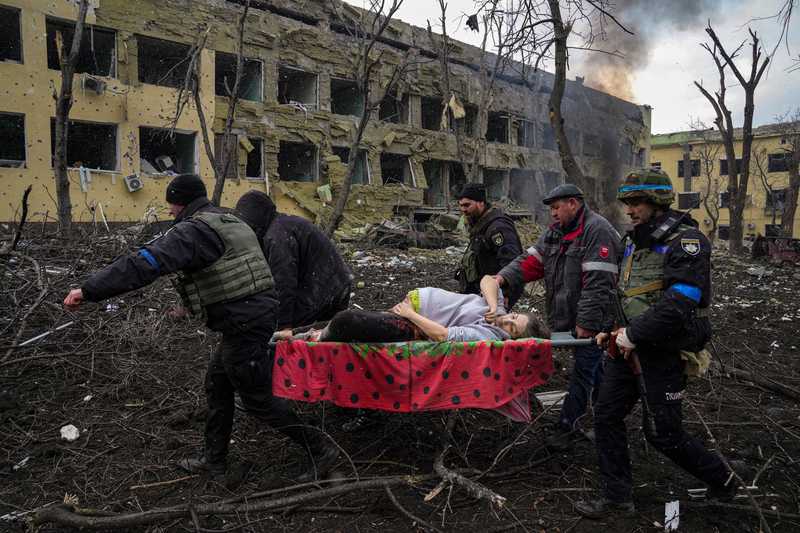 Ukrainian emergency employees and police officers evacuate injured pregnant woman Iryna Kalinina, 32, from a maternity hospital that was damaged by a Russian airstrike in Mariupol, Ukraine, March 9, 2022. (AP Photo/Evgeniy Maloletka)