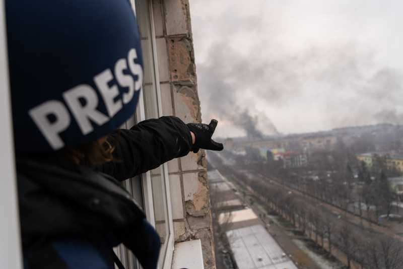 Photographer Evgeniy Maloletka points at the smoke rising after an airstrike on a maternity hospital in Mariupol, Ukraine, March 9, 2022. From 20 Days in Mariupol. (AP Photo/Mstyslav Chernov)