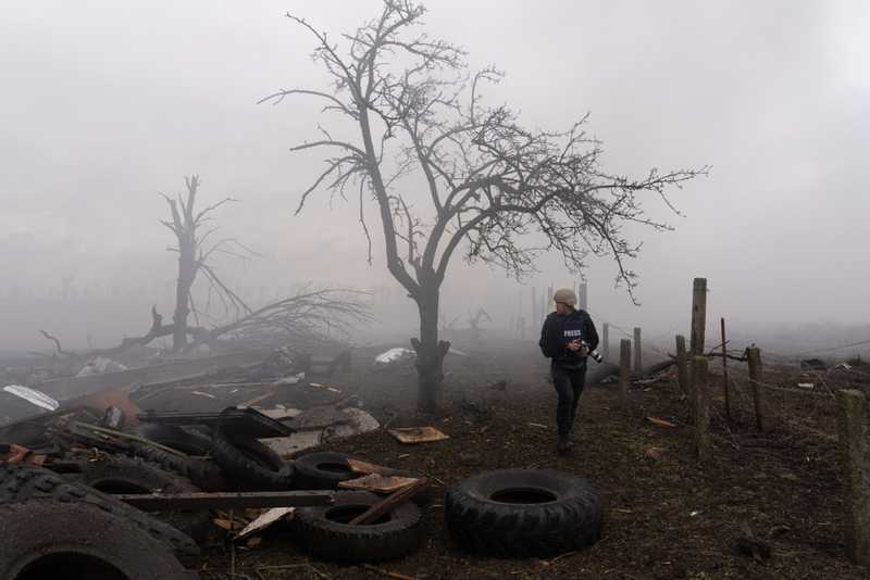 Photographer Evgeniy Maloletka picks his way through the aftermath of a Russian attack in Mariupol, Ukraine, Feb. 24, 2022. From 20 DAYS IN MARIUPOL. (AP Photo/Mstyslav Chernov)